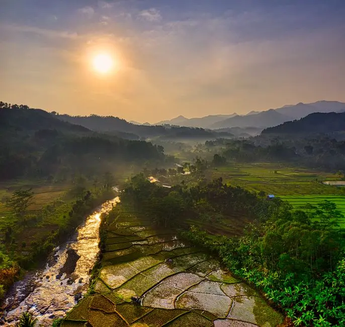 Pemandangan tebing granit Lembah Harau dengan sawah bertingkat di depannya